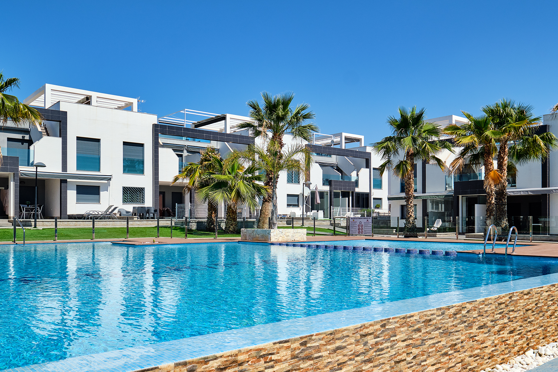 Pool at a condominium with blue water on a sunny day.