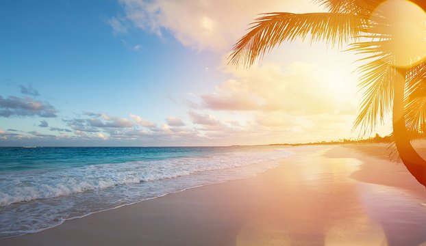 Océano al atardecer con una playa tropical vacía